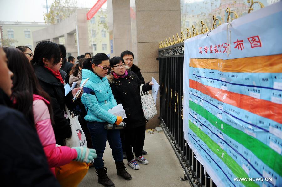 Examinees watch the map of examination rooms of the 2013 civil service exams in Shijiazhuang, capital of north China's Hebei Province, Nov. 25, 2012. More than 1.5 million people took part in the nationwide exams in China to qualify for about 20,000 state civil service posts on Sunday. (Xinhua/Zhu Xudong)