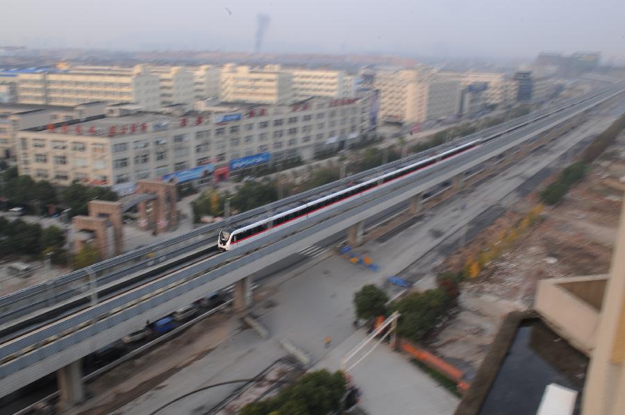 A subway train passes a suburban district in Hangzhou, capital of east China's Zhejiang Province, Nov. 24, 2012. Hangzhou Subway Line 1, the first subway in Zhejiang covering a distance of 47.97 kilometers, was put into a trial operation on Saturday after five years of construction. (Xinhua/Huang Zongzhi) 