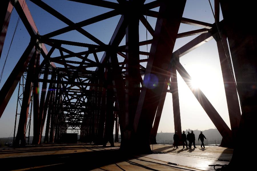 Several workers walk at the construction site of the Beijing-Guangzhou Railway bridge across the Yellow River in Zhengzhou, capital of central China's Henan Province, Nov. 26, 2012. The bridge, which is projected to be completed by the end of 2013, is the 6th Yellow River bridge planned to be built in Zhengzhou. (Xinhua/Zhu Xiang)