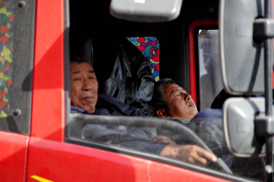 Drivers wait in a truck on the Jingtai Highway in Jinan, east China's Shandong Province, Nov. 26, 2012. Several traffic accidents happened on the highway and caused a traffic jam on Monday.(Xinhua/Xu Suhui) 