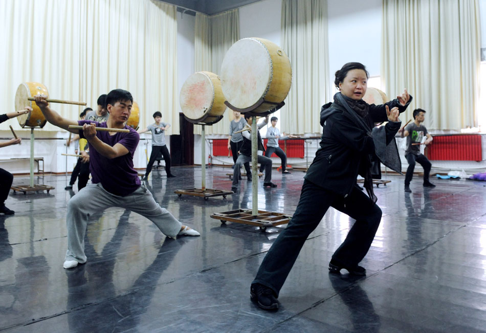 Director and choreographer Tong Ruirui (front) instructs performers during the rehearsal of the dance drama Goddess And The Dreamer in Zhengzhou, capital of central China's Henan Province, March 22, 2012. (Xinhua/Zhao Peng)