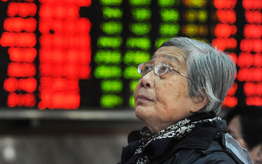 An investor looks at an electronic board showing stock information at a stock trading hall in Shanghai, east China, Nov. 27, 2012. Chinese stocks continued to fall Tuesday, with the benchmark Shanghai Composite Index dipping 1.3 percent, or 26.3 points, to end at 1,991.17, the lowest level since February 2009. The Shenzhen Component Index closed at 7,936.74, down 79.33 points, or 0.99 percent. (Xinhua/Zhu Lan)