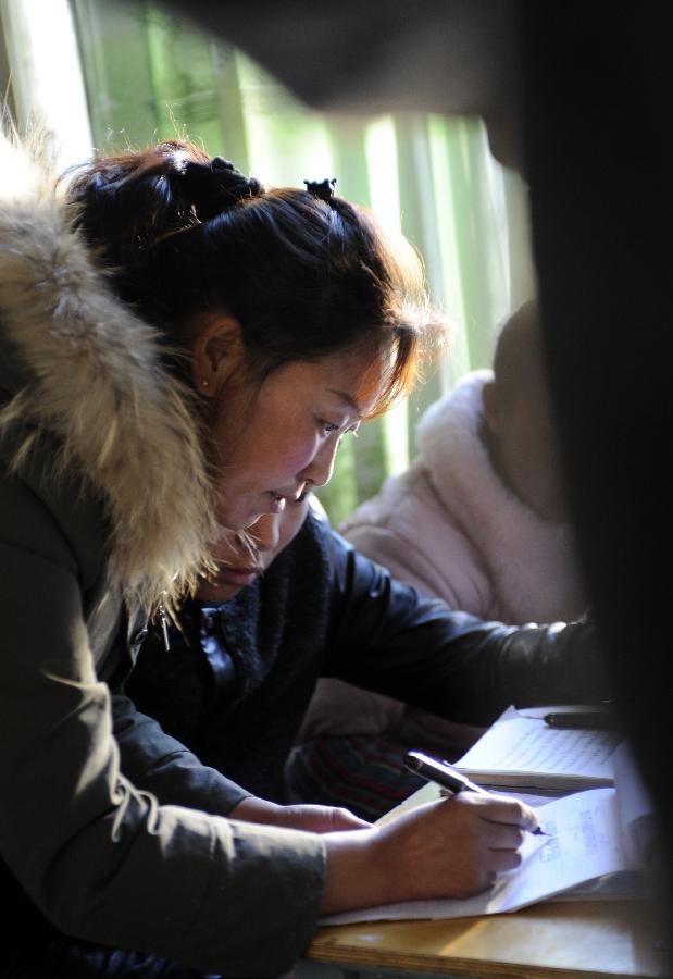 A teacher (L) offers guidance to a student during a Tibetan language course at Dhungker Language School in Lhasa, capital of southwest China's Tibet Autonomous Region, Nov. 22, 2012. (Xinhua/Chogo)