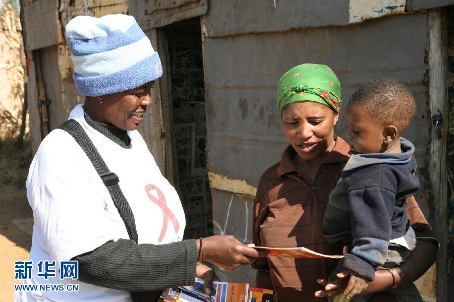 A volunteer from the "Khomanani Campaign" distribute HIV/AID prevention brochures to local residents in Johannesburg, South Africa on June 8, 2006. The "Khomanani Campaign" is to publicize HIV prevention, treatment, care and support in South Africa since 2001. (Xinhua/ Wang Ying) 