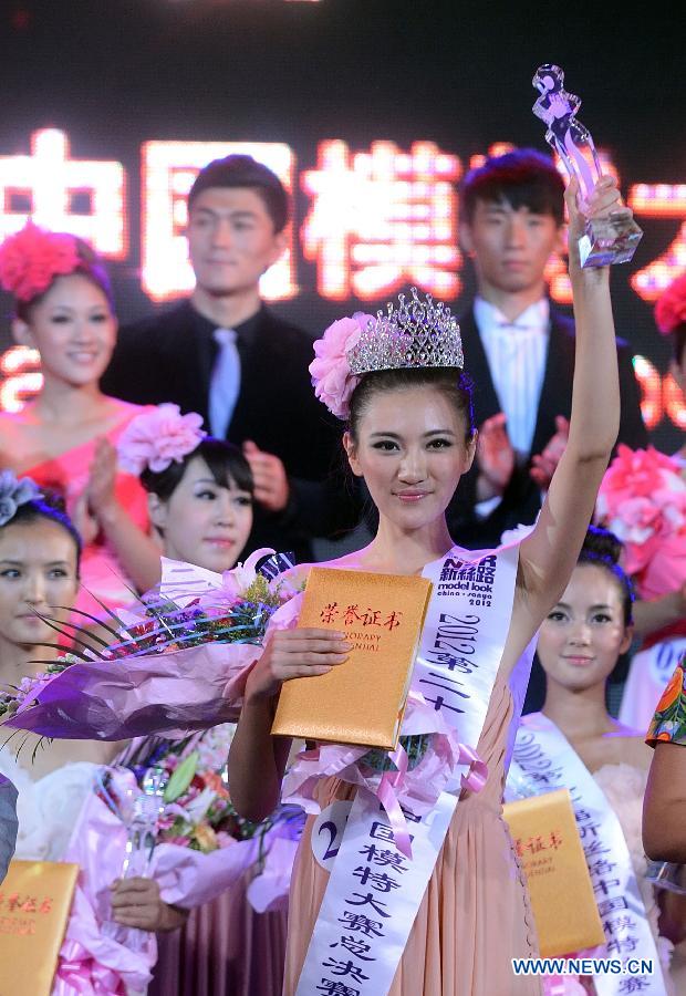 The "super model" winner Li Jingxue (front) shows her trophy in a model competition in Sanya, south China's Hainan Province, Nov. 30, 2012. The final of the 20th New Silk Road Model Competition was held here on Friday. (Xinhua/Jin Liangkuai)