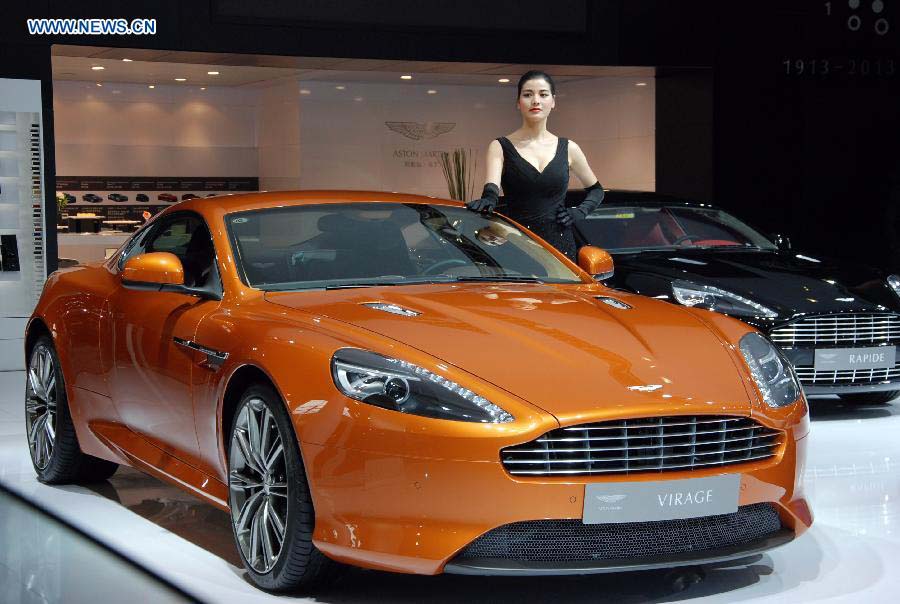 A car model presents an Aston Martin sports car at the 10th China (Guangzhou) International Automobile Exhibition in Guangzhou, capital of south China's Guangdong Province, Dec. 2, 2012. The ten-day auto show, which kicked off on Nov. 23, 2012, closed on Sunday. (Xinhua/Yuan Hongwei) 