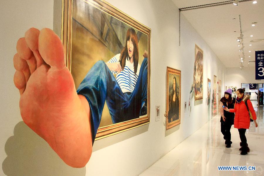 Visitors look at a three dimensional painting during an exhibition in Tianjin, north China, Dec. 1, 2012. (Xinhua/Wang Qingyan)