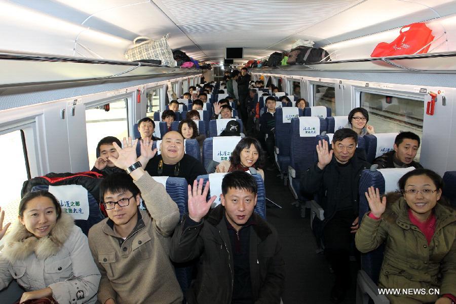 Passengers pose as they take the D501 high-speed train from Dalian North Railway Station to Harbin West Railway Station, Dec. 1, 2012. The world's first high-speed railway in areas with extremely low temperature, which runs through Liaoning, Jilin and Heilongjiang provinces in northeastern China, started operation on Saturday. The railway links Harbin, capital of Heilongjiang , and Dalian, a port city in Liaoning. (Xinhua/Zhang Chunlei)