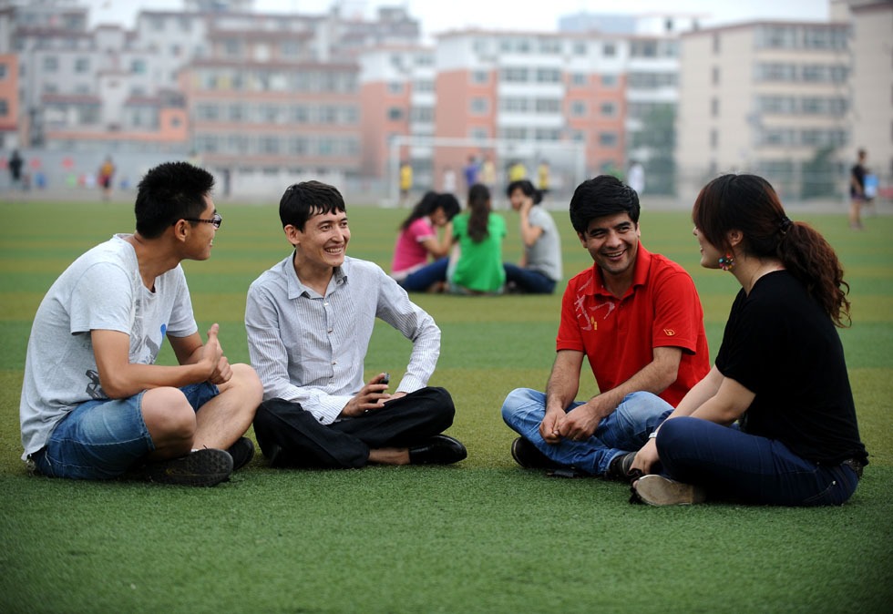 Salman Raha (2nd L) talks with classmates on the playground at Taiyuan University of Technology in Taiyuan, capital of north China's Shanxi Province, June 27, 2012. 