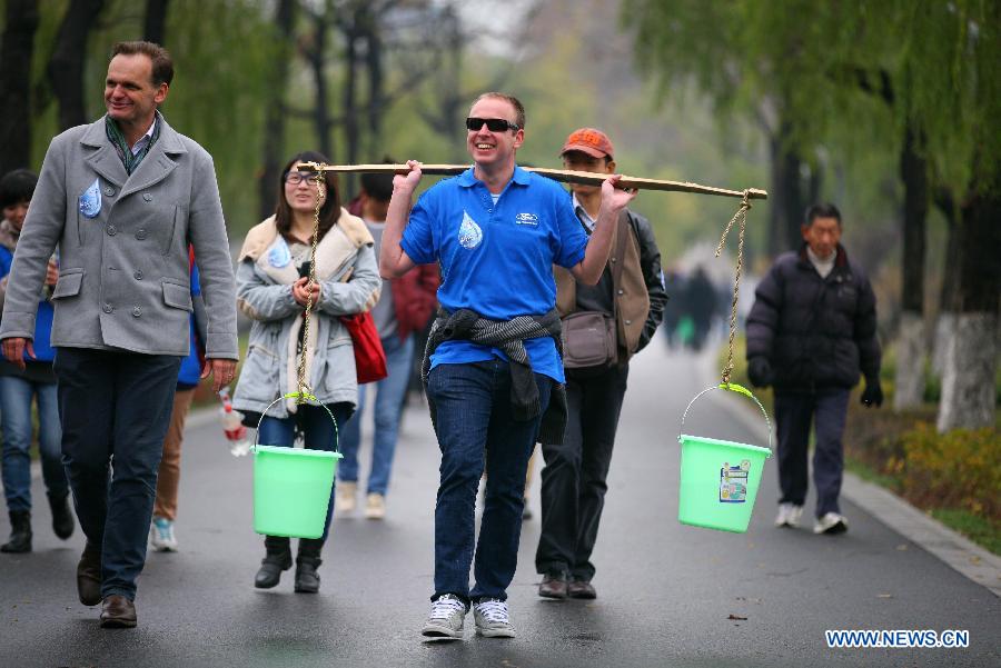 Foreigners attend a large-scale fund raising public activity at the Xuanwuhu Park in Nanjing City, capital of east China's Jiangsu Province, Dec. 2, 2012. A fund of more than 100,000 RMB yuan(16,000 U.S. dollars), raised in the public activity, will be used to help relieve the difficulty of water drinking of residents in a mountain area of Yuanmou County, southwest China's Yunnan Province. (Xinhua/Wang Xin)