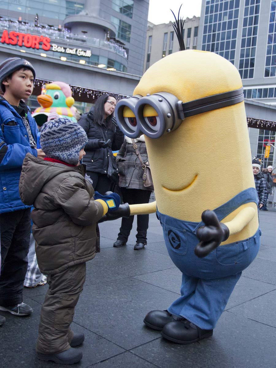 A performer dressed up as a cartoon character plays with the kids at the Children’s Carnival in Toronto, Canada, Dec. 1, 2012. The Toronto winter Children Carnival was held on the Dundas square on that day, including the entertainment performance, science and education display, which has attracted many children to come with their parents. (Xinhua/Zhou Zheng)