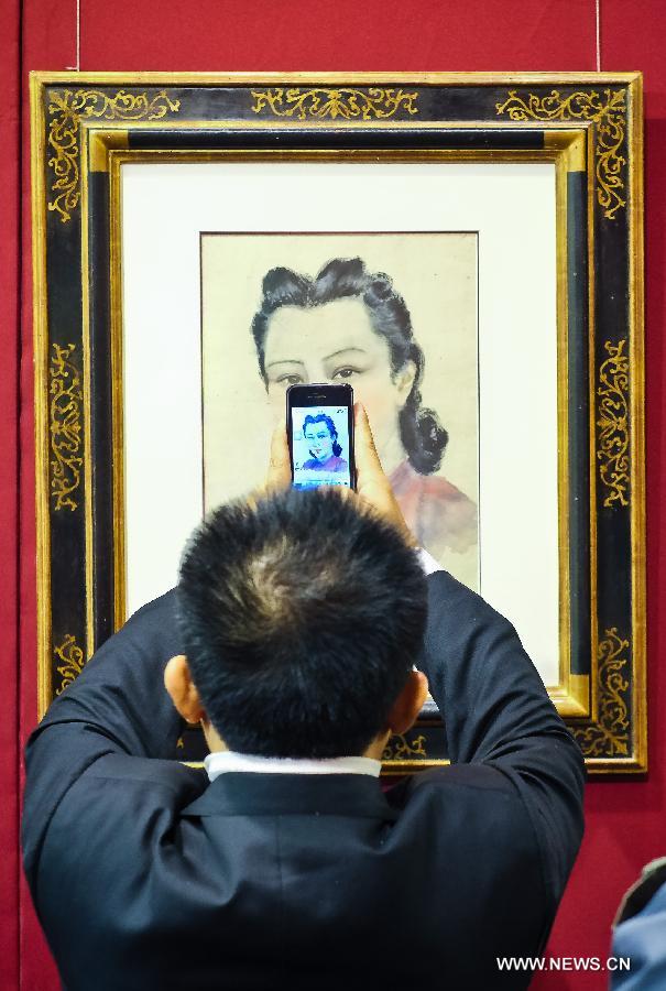 A man takes pictures of a painting displayed during the preview of Beijing Council 2012 Autumn Auction held in Beijing International Hotel Convention Center in Beijing, capital of China, Dec. 3, 2012. The preview, which kicked off on Sunday, showcased over 2500 artworks of different varieties such as paintings, chinaware and sculptures. The auction will last from Dec. 5 to Dec. 7. (Xinhua/Zhang Cheng)  