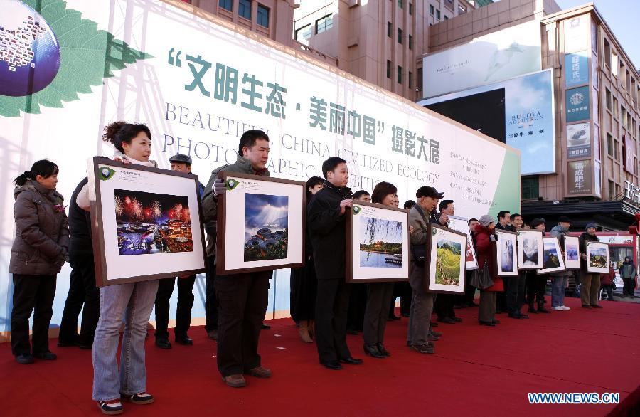 Photographers present photos in the "Beautiful China Civilized Ecology Photographic Exhibition" in the Wangfujing Street in Beijing, capital of China, Dec. 5, 2012. A total of 116 pieces of photo works were on display. (Xinhua/Wu Chenghuan)