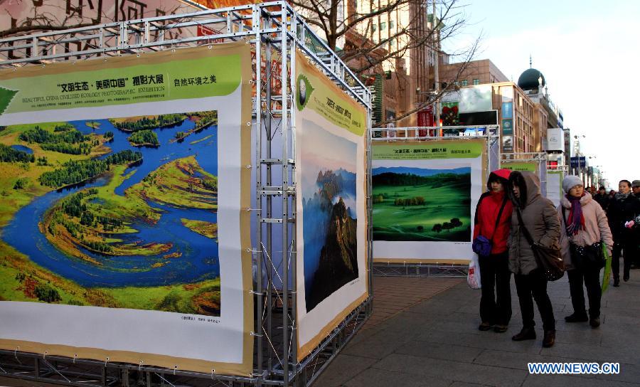 People watch photos presented in the "Beautiful China Civilized Ecology Photographic Exhibition" in the Wangfujing Street in Beijing, capital of China, Dec. 5, 2012. A total of 116 pieces of photo works were on display. (Xinhua/Wu Chenghuan) 