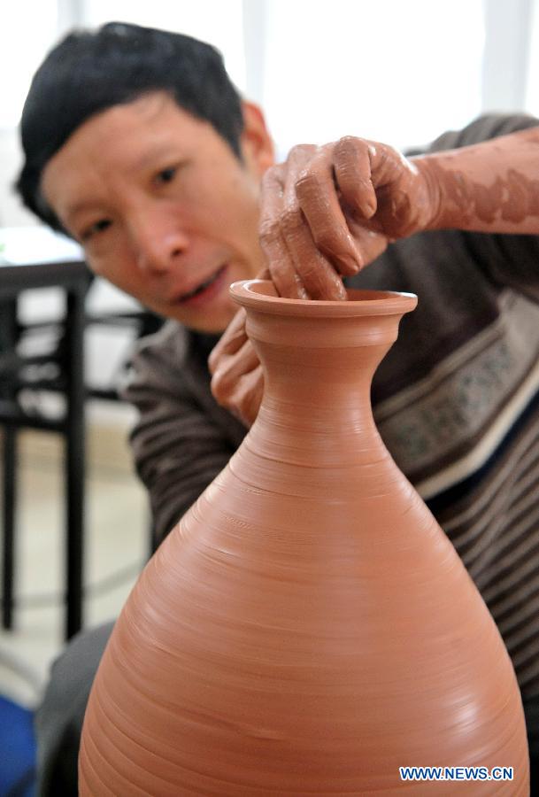 A contestant makes a ceramic artwork during a contest for ceramics-making in Qinzhou City, south China's Guangxi Zhuang Autonomous Region, Dec. 6, 2012. Altogether 142 contestants took part in the event. (Xinhua/Chen Ruihua)