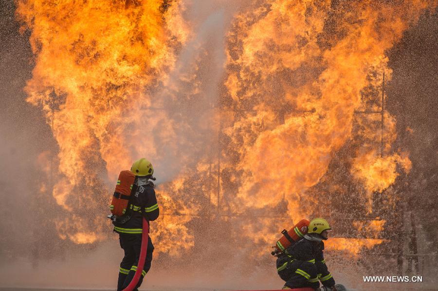 Fire fighters put out a fire during a joint search and rescue exercise in Chongqing, southwest China, Dec. 6, 2012. The joint exercise was held on Thursday to celebrate that the National (Chongqing) Land Search and Rescue Base was officially put into service. (Xinhua/Chen Cheng)