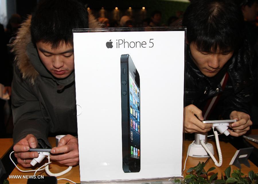 South Korean customers play with the iPhone 5 during the iPhone 5 launch event in Seoul, South Korea, Dec. 7, 2012. (Xinhua/Park Jin-hee)
