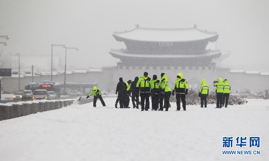 Policemen sweep snow on the Gwanghwamun Square in Seoul, Dec. 5, 2012. Seoul was hit by a heavy snow on that day. The local police department has issued the “traffic security emergency alarm”, to deal with the possible traffic issues caused by the heavy snow. (Xinhua/Yao Qilin)