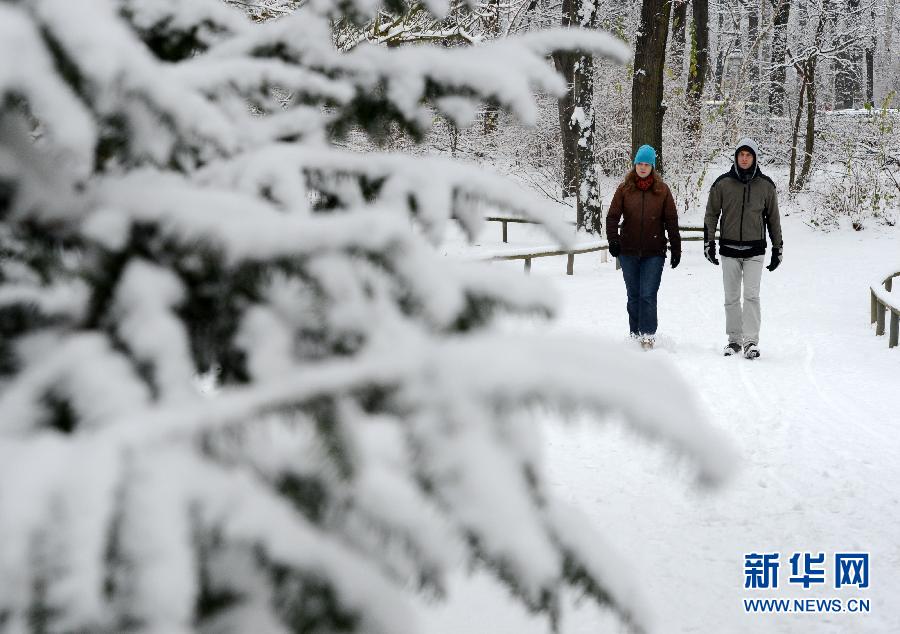 Two people walk in the snow in a park in Berlin, Germany, Dec. 6, 2012. Berlin had its first heavy snow since winter on that day. (Xinhua/Ma Ning)