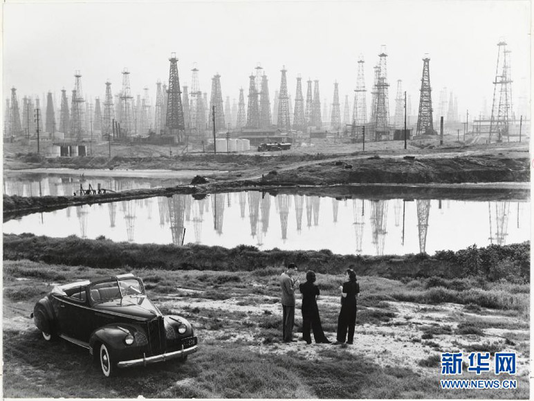 "People chat by a car parked by a field of oil rigs on Signal Hill, California, 1941" by B. Anthony Stewart, sold for 1,250 U.S. dollars at Christie’s on New York on Dec 6, 2012. (Xinhua/B. Anthony Stewart/National Geographic/Christie's Images) 