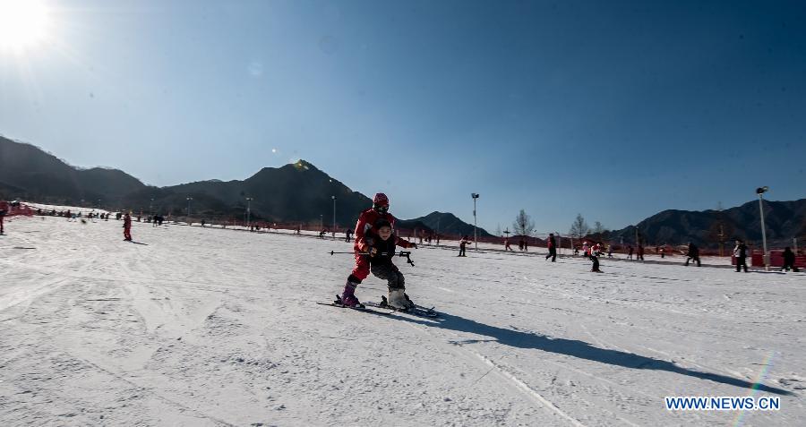 A child skis with the instruction of a coach at "Kuangbiao Leyuan" park in Beijing, capital of China, Dec. 9, 2012. As the temperature continued to decrease, Beijing has entered skiing boom season. (Xinhua/Zhang Yu) 
