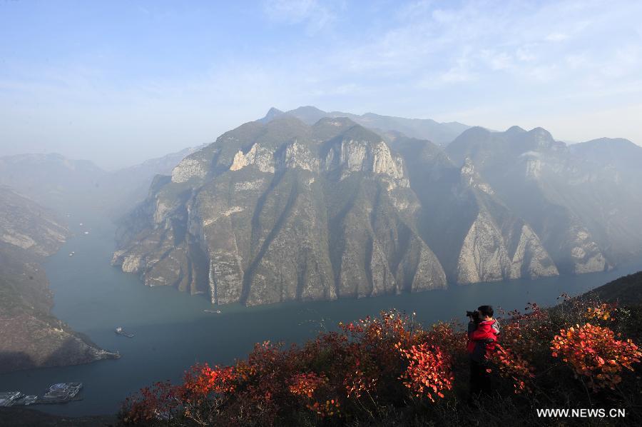 A visitor takes photo for red leaves in Wuxia Gorge of the Three Gorges area in Chongqing Municipality, southwest China, Dec. 8, 2012. (Xinhua/Zheng Jiayu)