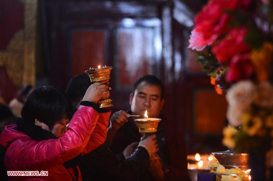 A devotee of Tibetan Buddhism holds a butter-lamp for blessing during the Butter-lamp Festival in Taer Monastery in Huangzhong County, northwest China's Qinghai Province, Dec. 8, 2012. The annual Butter-lamp Festival falls on the 25th day of the 10th month of the Tibetan calendar every year in commemoration of Tsong Khapa, the founder of the Gelug sect of Tibetan Buddhism.[Photo/Xinhua]