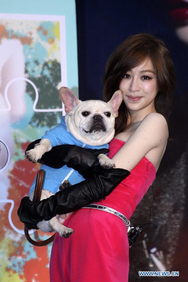 Singer Cyndi Wang poses for pictures with her pet dog at an autograph session promoting her new album "Love or not?" in Taipei, southeast China's Taiwan, Dec. 9, 2012. (Xinhua) 