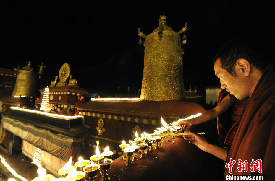 Photo shows the monks lighting the butter lamps in Jokhang Monastery. (Chinanews.com/ Li Lin)