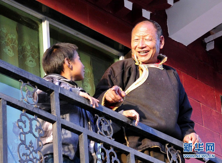 Chosang is chatting with the veteran Thangka master Sonam Jokteng on the balcony, Dec.06, 2012.(Photo/Xinhua)