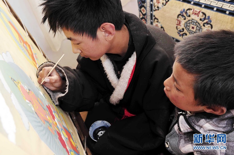 Chosang is learning from a senior student, Dec.06, 2012(Photo/Xinhua)