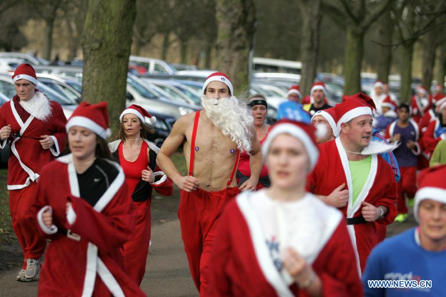 People dressed as Santa Claus take part in the "Santa run" at Greenwich Park in London, Britain, on Dec. 9, 2012. (Xinhua/Bimal Gautam) 