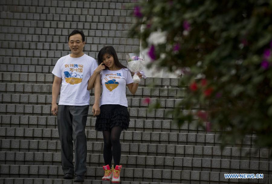 A newly married couple steps out of the marriage registration hall in Hong Kong, south China, Dec. 12, 2012. A total of 696 couples flocked to tie the knot on Dec. 12, 2012, or 12/12/12, which sounds like "will love/will love/will love" in Chinese. (Xinhua/Lui Siu Wai)
