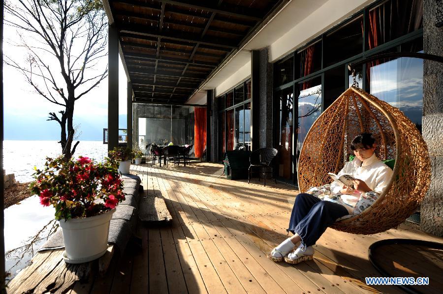 A tourist read a book in Shuanglang County in Dali, southwest China's Yunnan Province, Dec. 12, 2012. (Xinhua/Qin Qing) 