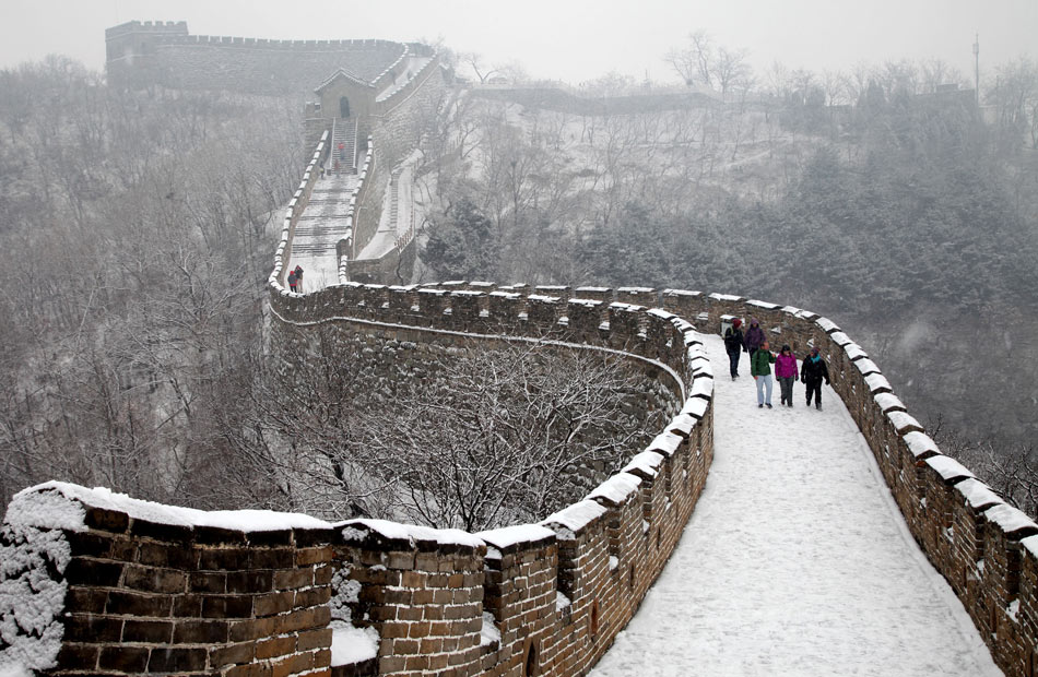 Tourists climb the Great Wall in snow in snow in Beijing, capital of China, on Dec. 12, 2012. A snow hit the city on Wednesday. (Photo/Xinhua)