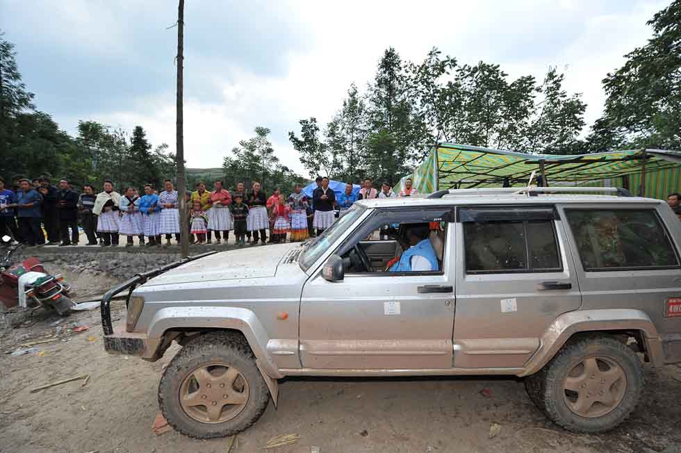 While Diarra Boubacar (in the vehicle) prepares to drive away after giving medical service, villagers sing songs to see him off in Boyi Village, Luozehe Town, Yiliang County, southwest China's Yunnan Province, Sept. 15, 2012.(Xinhua/Li Xin)