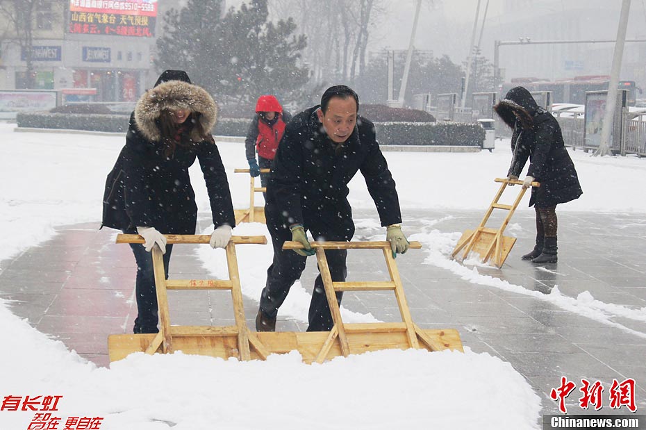 Local citizens clean snow-covered streets in Taiyuan, capital of north China's Shanxi Province, Dec. 13, 2012. Heavy snow battered parts of northern China on Thursday.(Photo/Chinanews.com)
