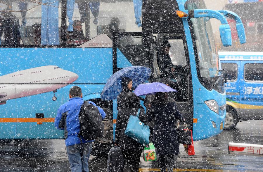 Passengers board on a bus in Qingdao, east China's Shandong Province, Dec. 18, 2012. The temperature will linger around zero degree centigrade starting on Dec. 20, according to the local meterological authority. (Xinhua/Li Ziheng)