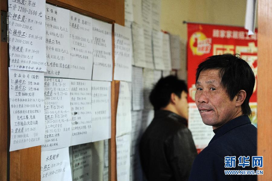 A migrant worker reads the recruitment information on Hangzhou's talent market on Feb. 2, 2012.