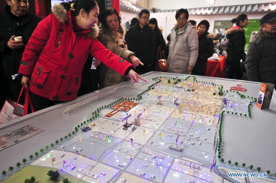 Visitors view a distribution map of care facilities for old people of Beijing's Dongcheng District during the Beijing International Senior Industry Expo 2012 in Beijing, capital of China, Dec. 19, 2012. The three-day expo opened here on Wednesday, showcasing products and services for senior citizens. (Xinhua/Wang Jingsheng)