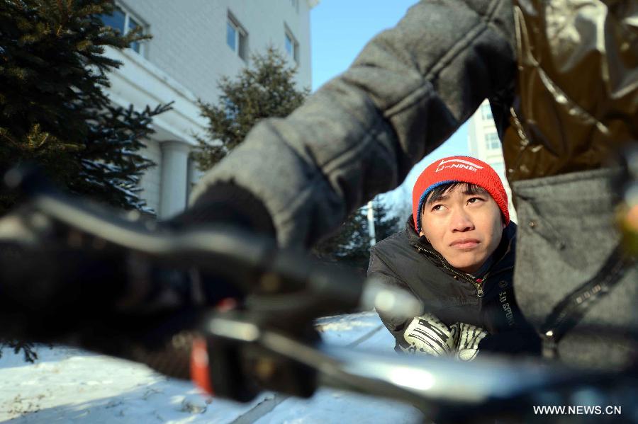 Disabled student Jiang Jian sits on his classmate Wang Junsheng's bicycle to the classroom at school in Harbin, capital of northeast China's Heilongjiang Province, Dec. 19, 2012. 