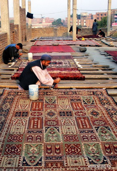 Pakistani men craft hand-made carpets at a local carpet factory in northwest Pakistan's Peshawar, Dec. 20, 2012. According to reports, Pakistan's carpet exports have witnessed a huge decline of more than 50 percent during the last five years. (Xinhua/Ahmad Sidique)