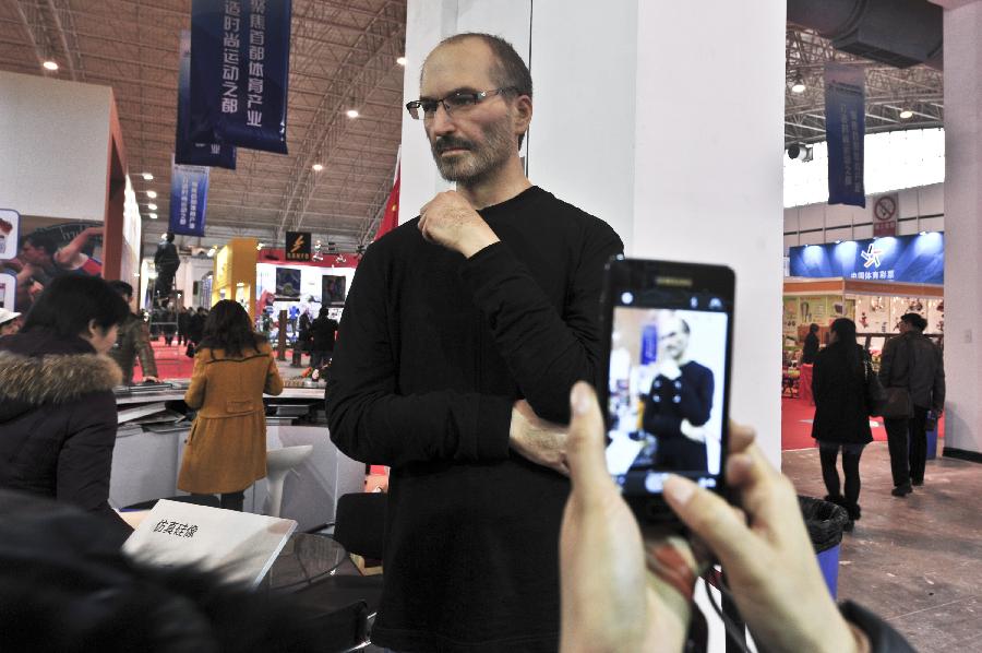 A visitor takes a photo of the high-imitation silicon figure of Steve Jobs during the 7th China (Beijing) International Cultural and Creative Industry Expo (ICCIE) in Beijing, capital of China, Dec, 20, 2012. The expo, which opened here on Thursday, attracted some 50 delegations from 6 international organizations and 15 countries and regions. (Xinhua/Wang Jingsheng) 