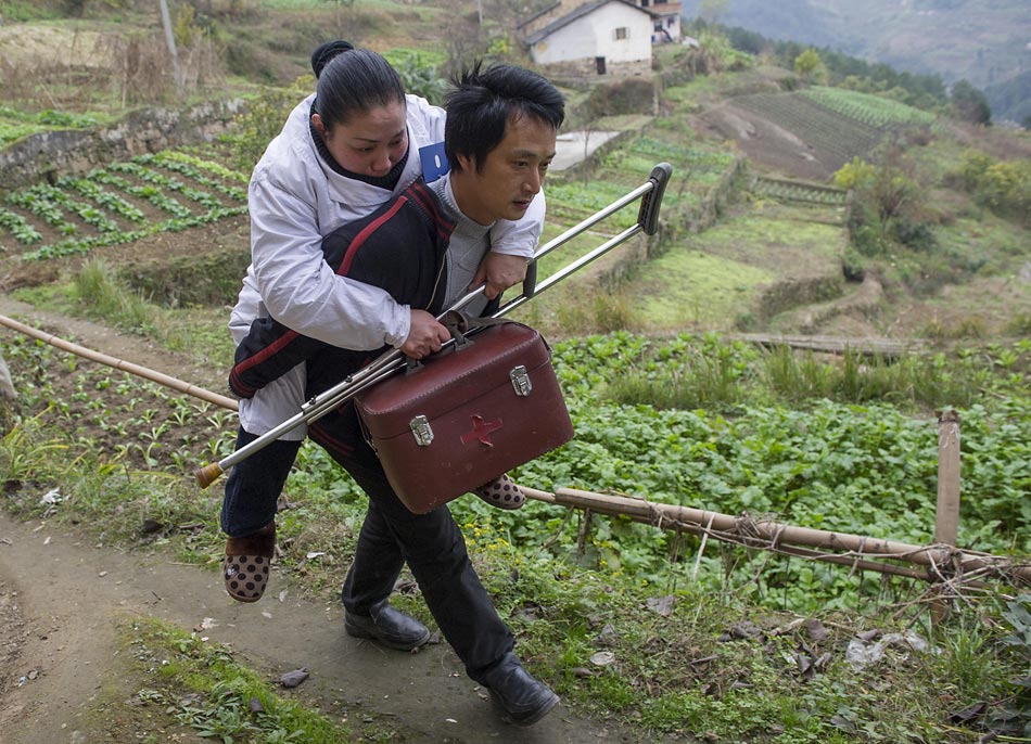 Ai Qi carries Dr. Zhou Yuehua to visit patients on Dec. 15, 2012. (Xinhua/Chen Cheng)
