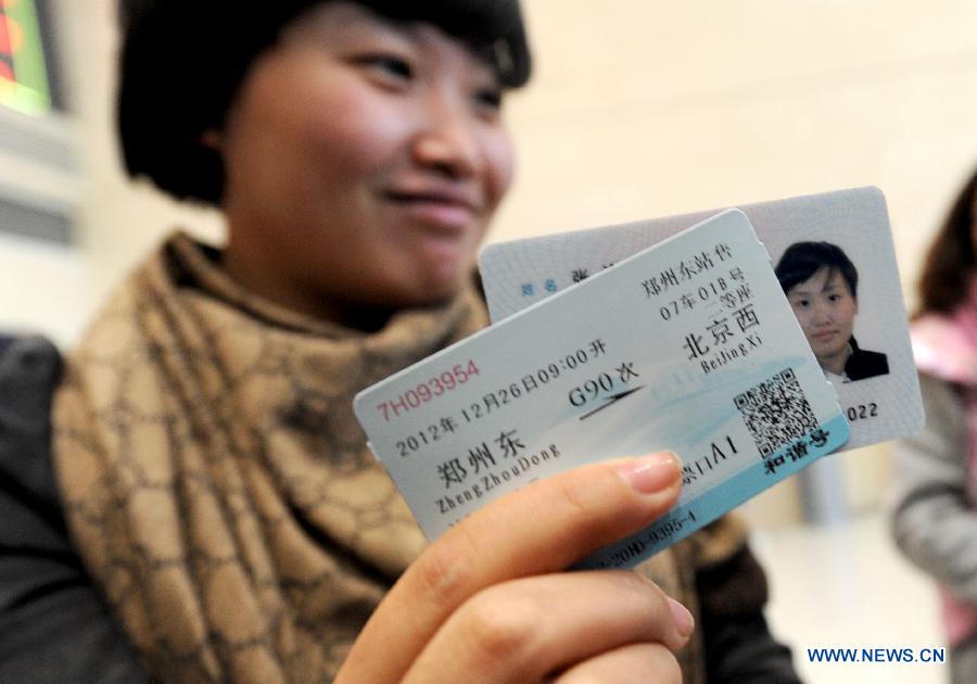 A woman buys the first ticket of a high-speed train from Zhengzhou to China's capital Beijing sold at the Zhengzhou East Railway Station in Zhengzhou, capital of central China's Henan Province, Dec. 20, 2012. (Xinhua/Zhu Xiang)