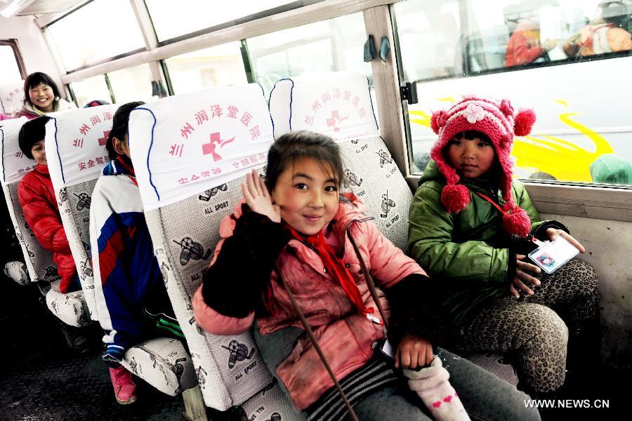 A girl student waves on a school bus in Gaolan county, Lanzhou city of northwest China's Gansu province, Dec. 21, 2012. According to local educational authorities, a total of 3,117 lines of school buses were put to use, providing service for more than 300,000 boarders of compulsory students. (Xinhua/Nie Jianjiang) 