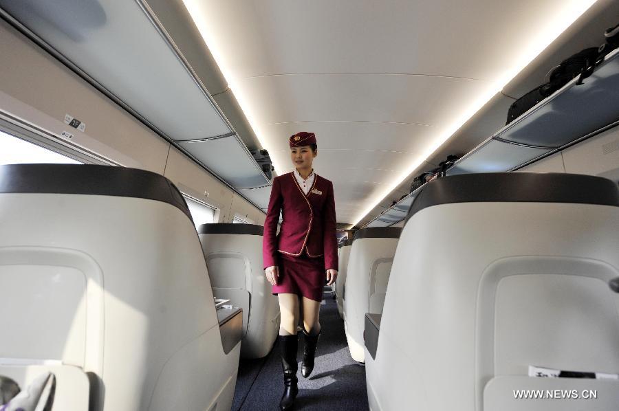 A stewardess walks through a bussiness class section of G80 express train during a trip to Beijing, capital of China, Dec. 22, 2012. (Xinhua/Chen Yehua) 