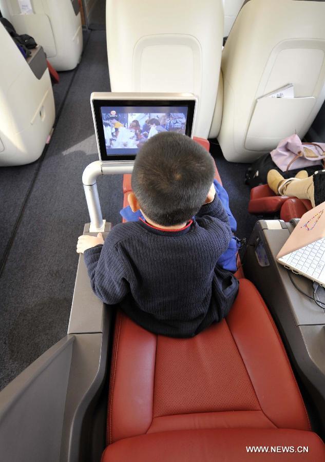 A child watches television in a business class carriage of G80 express train during a trip to Beijing, capital of China, Dec. 22, 2012. (Xinhua/Chen Yehua) 