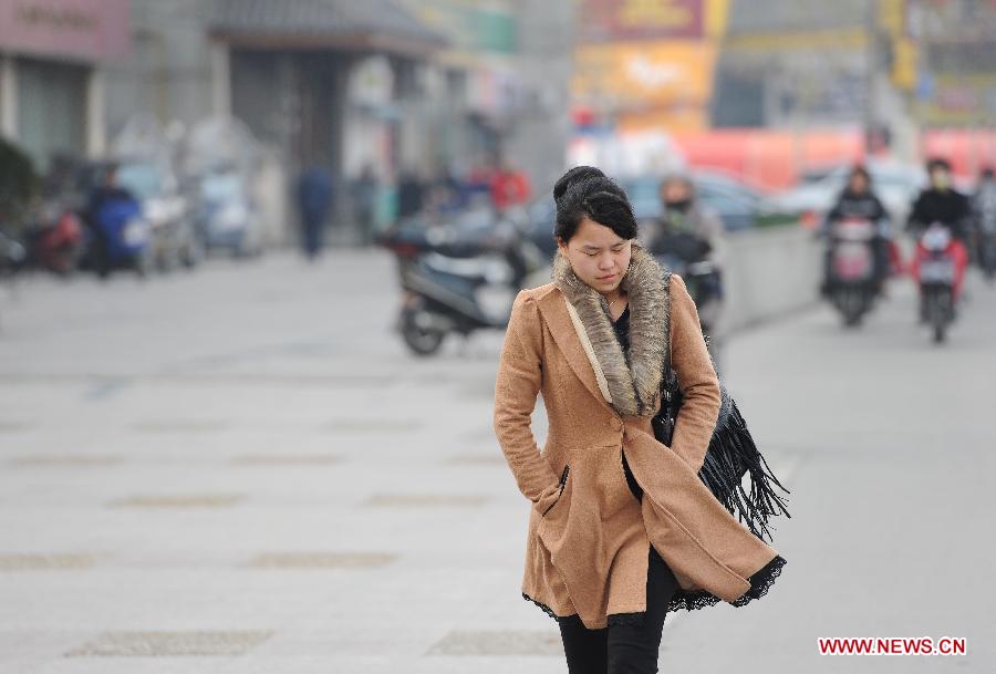 A woman walks against the wind on the Caobao Road in east China's Shanghai, Dec. 23, 2012. A severe cold wave is sweeping most parts of China, with temperatures dropping by around 10 degrees Celsius in some areas. The local meteorological authority issued an alert for the cold wave on Sunday. (Xinhua/Lai Xinlin) 
