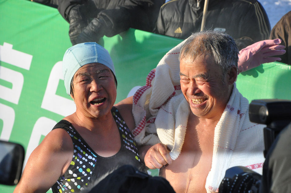 An aged couple participates in the 2012 China Halar Winter Swimming Tournament in Halar, Hulun Buir City in north China's Inner Mongolia Autonomous Region on the afternoon of Dec. 23, 2012. (People's Daily Online/Zeng Shurou)